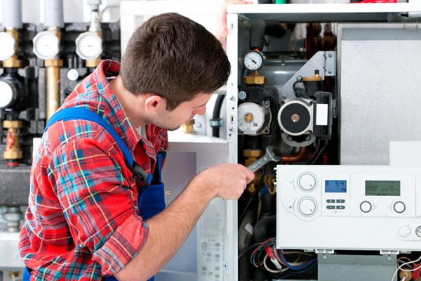 Heating technician repairing boiler controls in Claremont