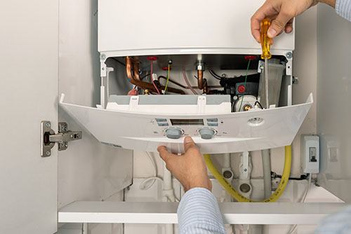 Heating technician repairing a residential boiler in Claremont