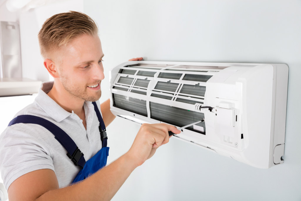 HVAC technician maintaining a ductless air conditioner in Claremont