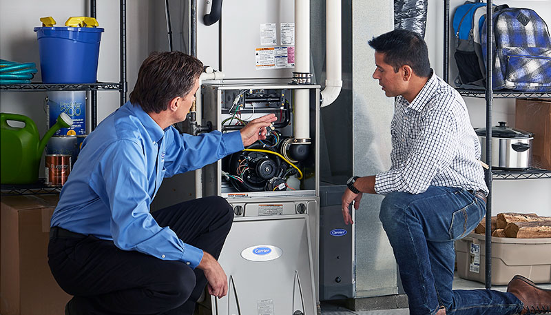 Technician evaluating a furnace for repair or replacement in Claremont