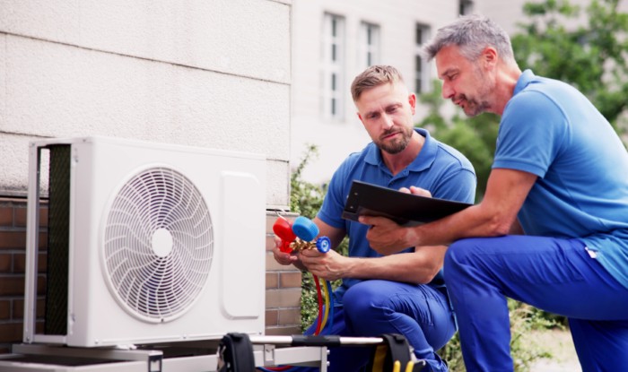 HVAC technicians installing an outdoor air conditioning unit in Claremont