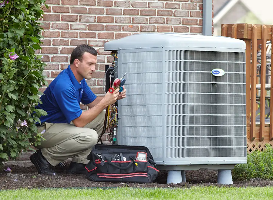HVAC technician inspecting an outdoor AC unit in Claremont